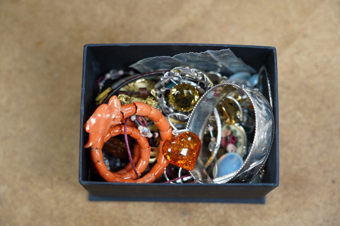 A small quantity of assorted jewellery including a coral set coiled dragon bracelet, a 1970's engraved silver hinged bangle, a Scottish silver and citrine brooch and costume. Condition - poor to fair to good